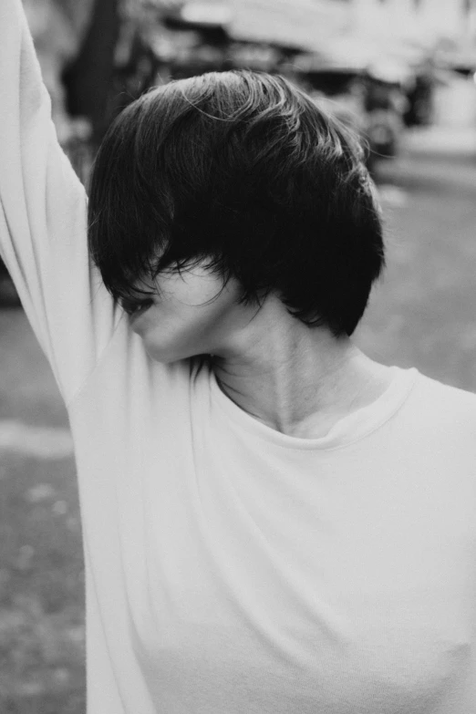 a black and white photo of a woman holding a frisbee, a black and white photo, inspired by jeonseok lee, pexels contest winner, realism, shaggy haircut, boy has short black hair, faceless, dressed in a white t shirt