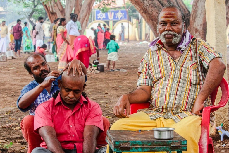 a couple of men sitting next to each other, samikshavad, curls on top of his head, on set, center of image, customers