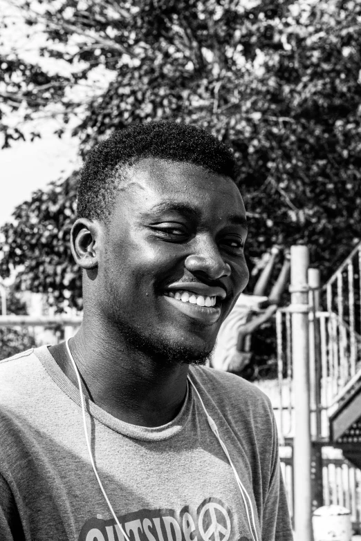 a black and white photo of a man smiling, inspired by Chinwe Chukwuogo-Roy, he is about 20 years old | short, ( ( dithered ) ), candid photo, in 2 0 1 5