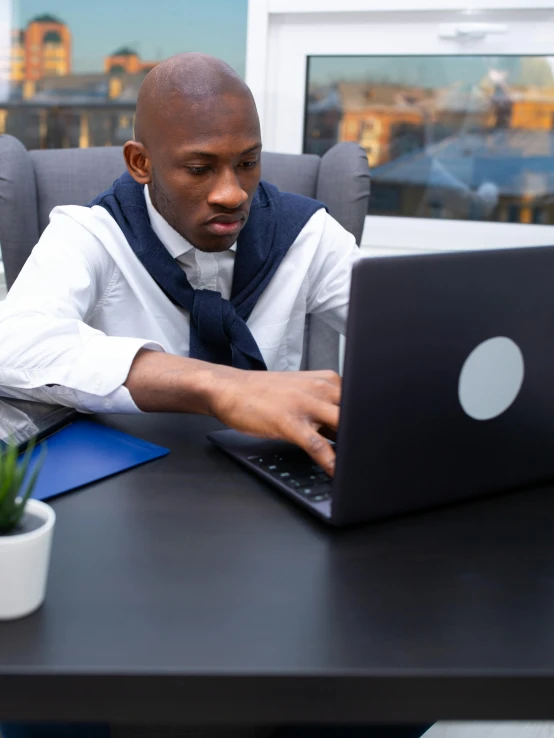 a man sitting at a desk using a laptop computer, a screenshot, pexels contest winner, diversity, ( ( theatrical ) ), african canadian, business clothes