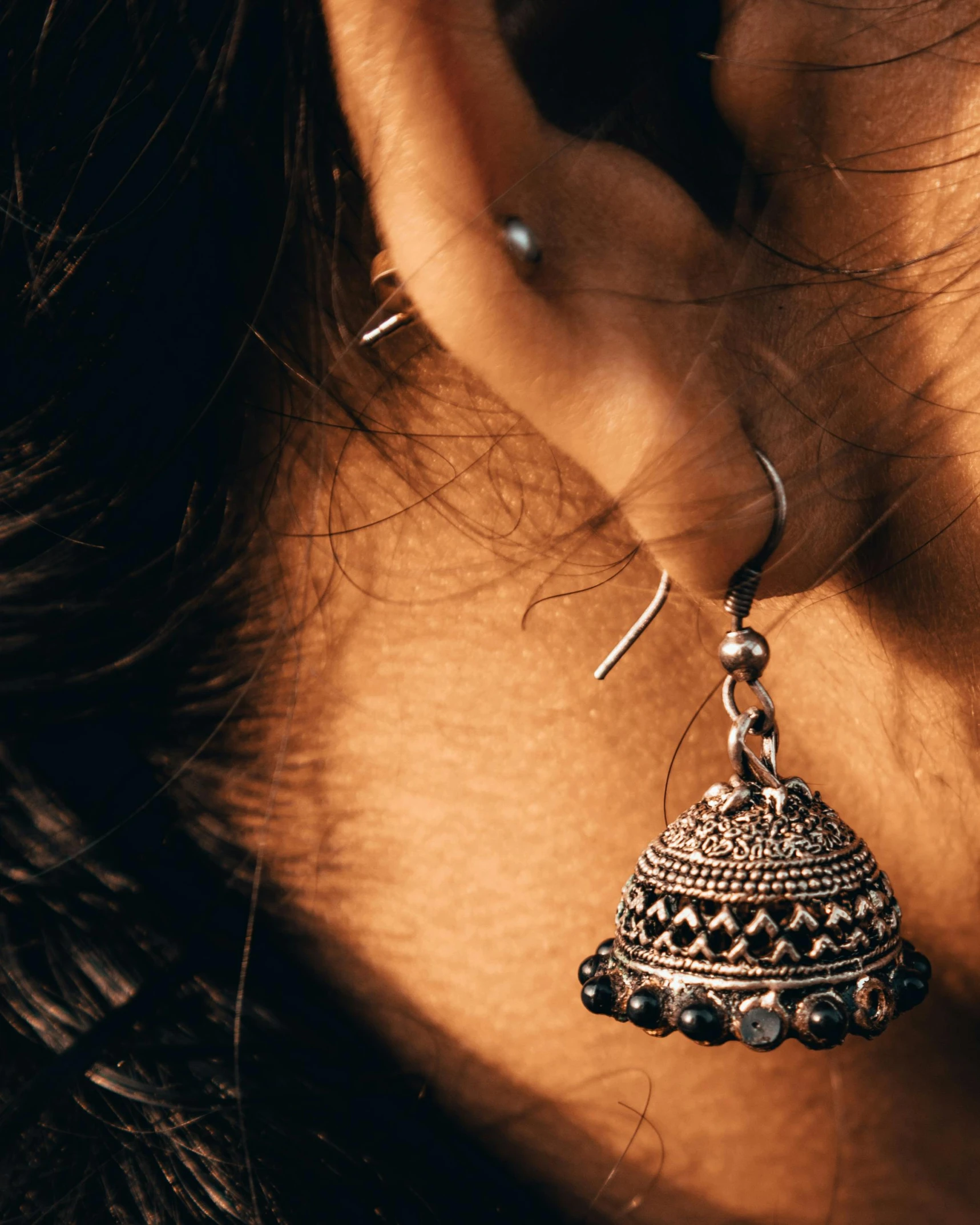 a close up of a person wearing a pair of earrings, by Hannah Tompkins, pexels contest winner, assamese aesthetic, black and silver, thumbnail, small ears