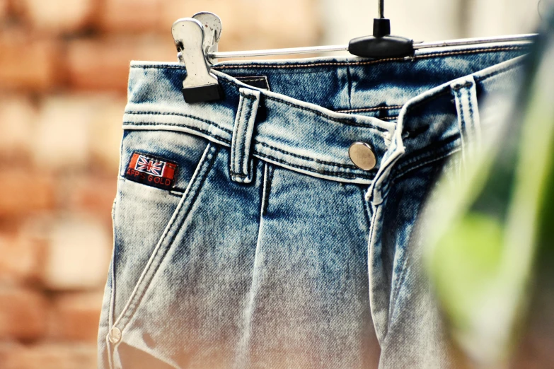 a pair of jeans hanging on a clothes rack, inspired by Elsa Bleda, unsplash, hdr detail, denim hot-pants, rock star, h. u. d