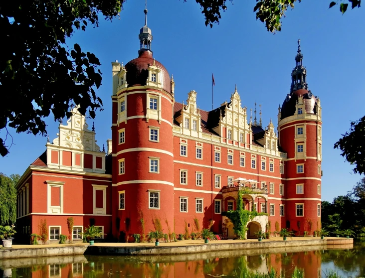 a large red building sitting next to a body of water, by Juergen von Huendeberg, pexels contest winner, art nouveau, turrets, van dyck, square, 15081959 21121991 01012000 4k