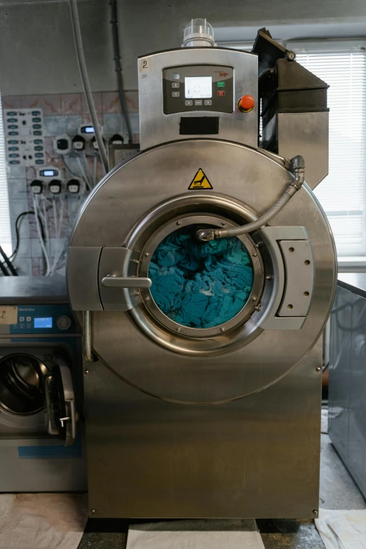 a machine that is sitting in a room, a silk screen, by Matija Jama, unsplash, in a laundry mat, blue - grey gear, chemisty, photographed for reuters