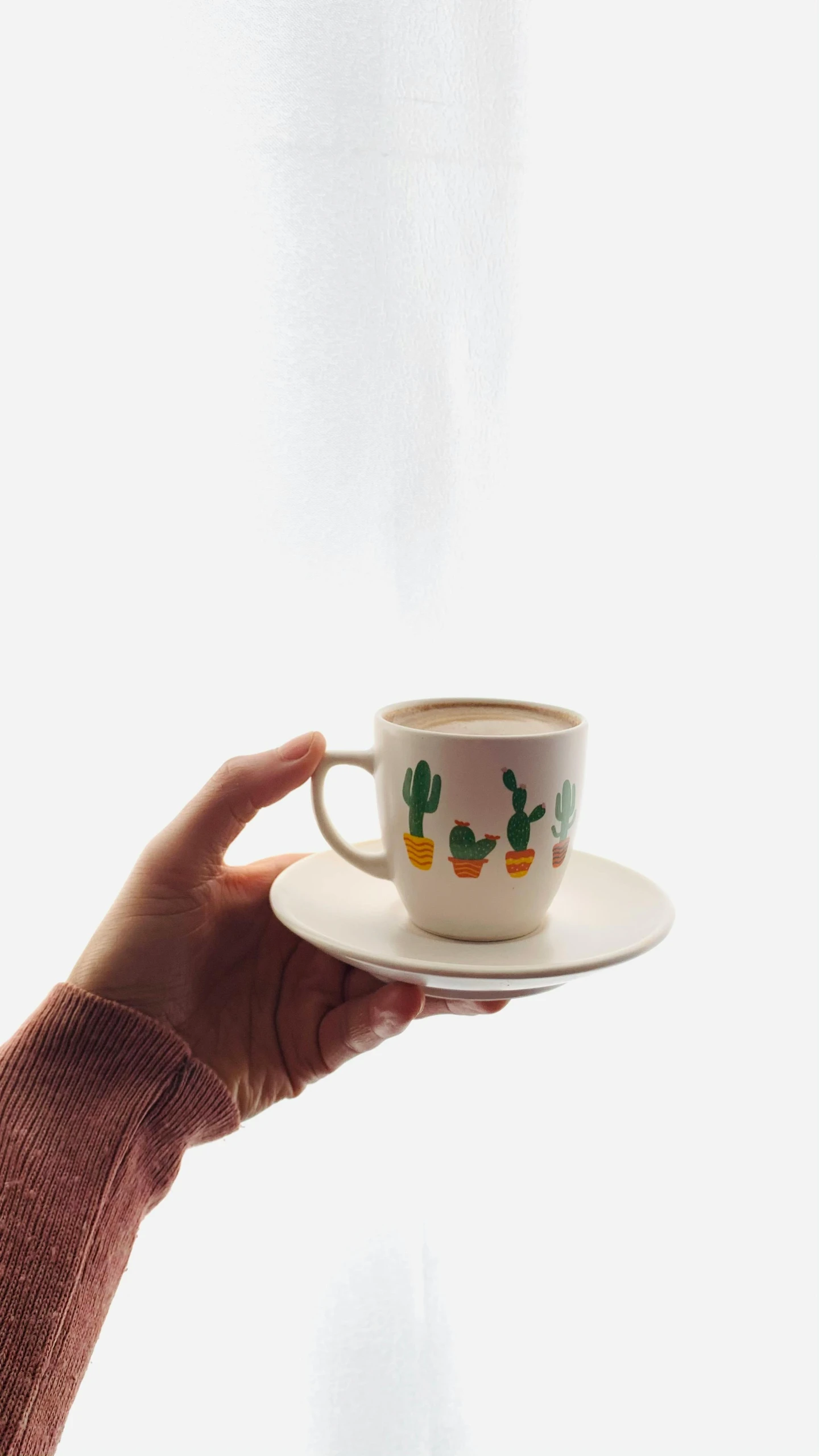 a person holding a cup and saucer in front of a window, a cartoon, trending on pexels, cacti, jakarta, low quality photo, coffee cup