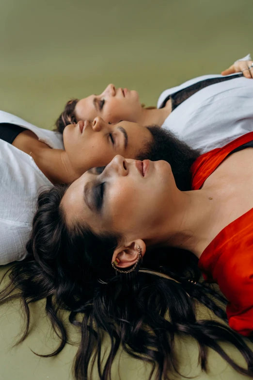 a couple of women laying on top of a tennis court, an album cover, inspired by Elsa Bleda, trending on pexels, aestheticism, three women, layed on a red velvet fabric, brunettes, sleepy expression