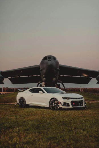 a white car parked in front of an airplane, military-grade, muscle cars, unsplash photo contest winner, ✨🕌🌙