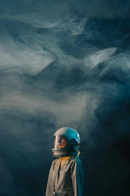 a man in a space suit standing in front of a dark background, an album cover, by Adam Marczyński, unsplash contest winner, smoke clouds, cyan atmosphere, fog mads berg, galaxy reflected in helmet