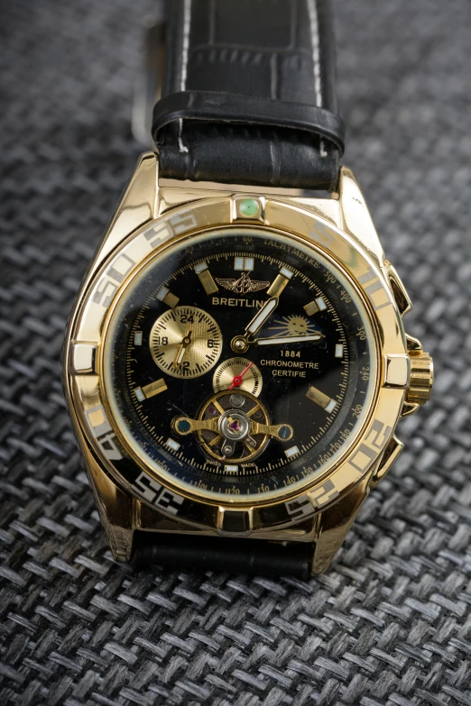 a close up of a watch on a table, by Kev Walker, gold wings, thumbnail, breitling, full front view