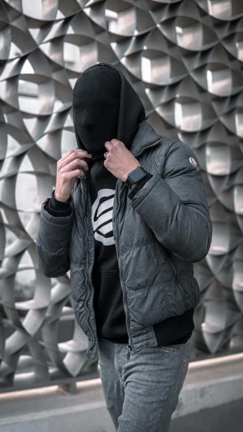 a man in a hoodie walking down a street, by Daarken, pexels contest winner, model wears a puffer jacket, discord profile picture, grey armor, darkslategray wall