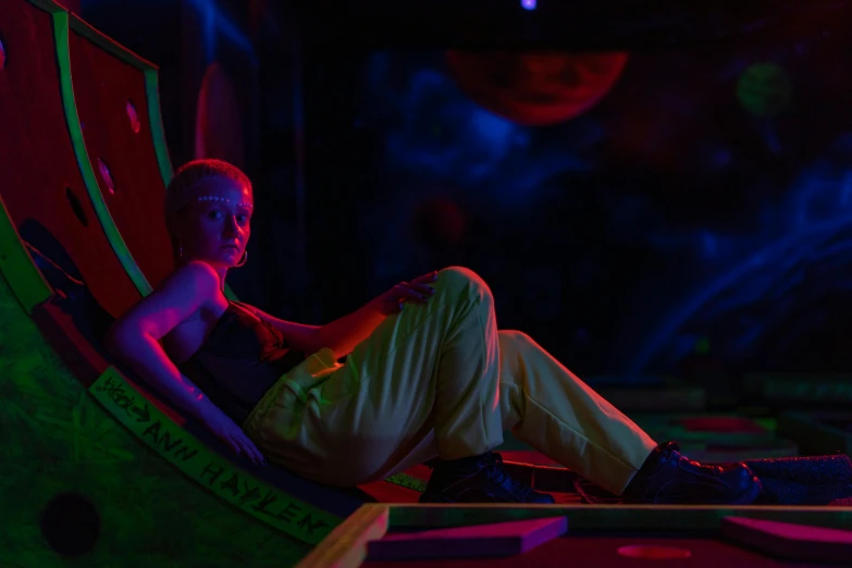 a man sitting in a chair in a dark room, cyberpunk art, pexels contest winner, holography, neon operator margot robbie, sitting on a moon, softplay, anya taylor joy