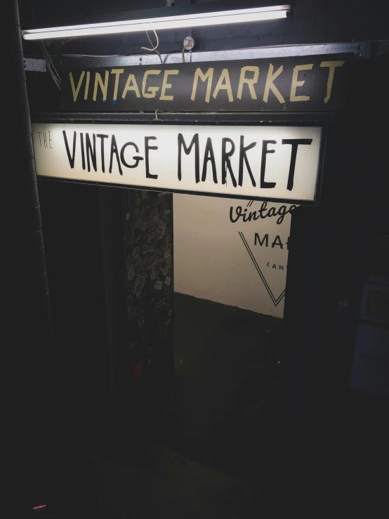 a black and white photo of a vintage market sign, a photo, trending on unsplash, it's night, 💋 💄 👠 👗, garage, vintage muted colors