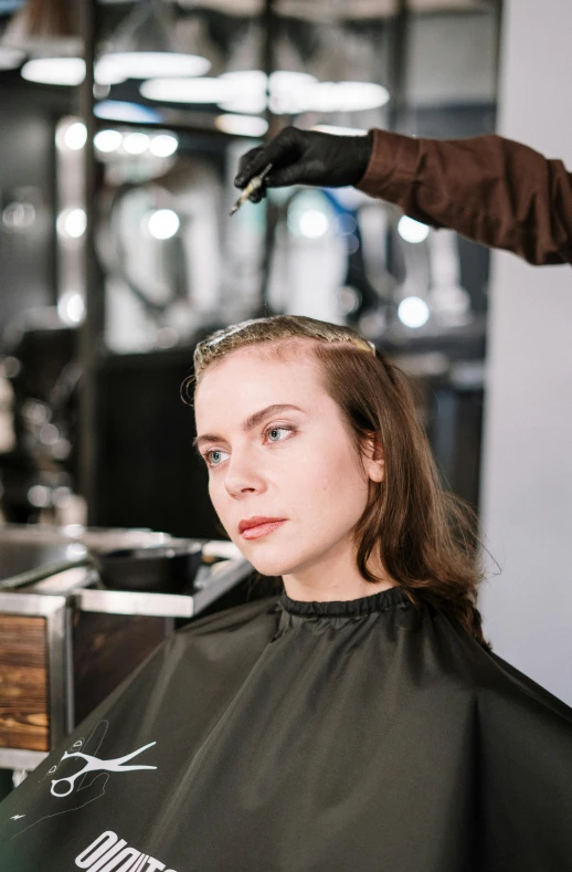 a woman getting her hair cut at a salon, a portrait, by Julia Pishtar, trending on pexels, receding hairline, half & half hair dye, model posing, brown haired