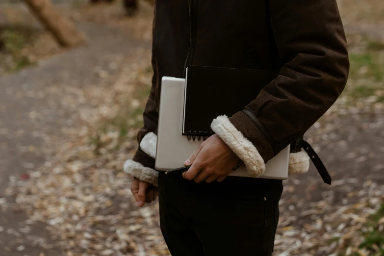 a man in a brown jacket holding a laptop, an album cover, trending on pexels, autumn season, furry arms, adventuring gear, white sleeves