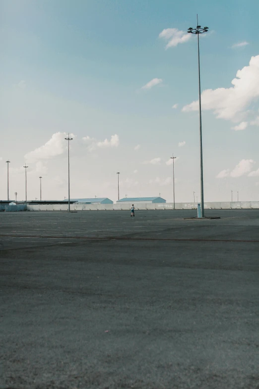 a man riding a skateboard on top of an airport tarmac, by Pablo Rey, postminimalism, desolate :: long shot, cars parked underneath, low quality photo, in a sci-fi shipping port