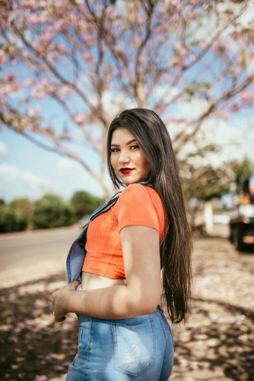 a beautiful young woman standing in front of a tree, by reyna rochin, pexels contest winner, long hair and red shirt, thicc, colombian, gif