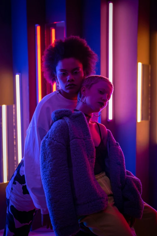 two people sitting next to each other in neon lights, inspired by Nan Goldin, trending on pexels, julia garner, willow smith zendaya, lesbian embrace, light room