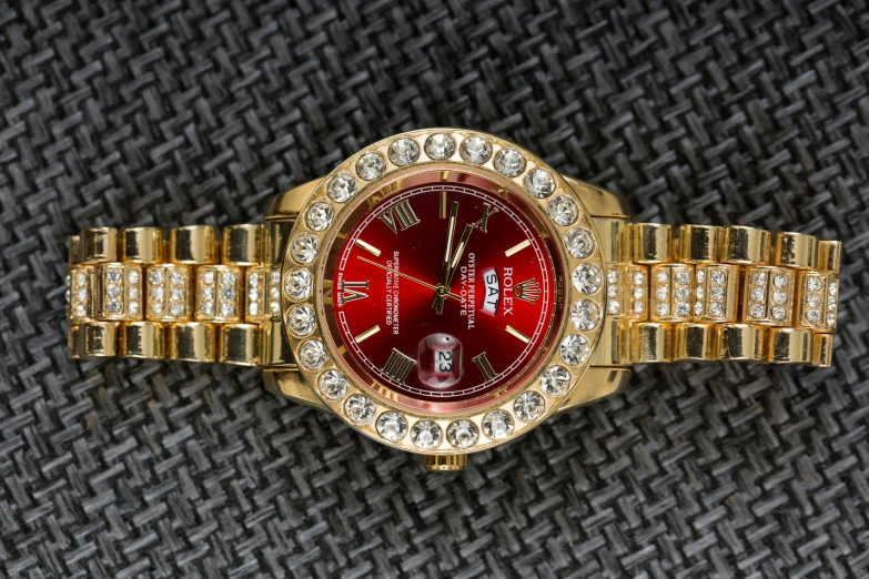 a close up of a watch on a table, pexels contest winner, renaissance, red and gold, with sparkling gems on top, rap bling, full body shot close up