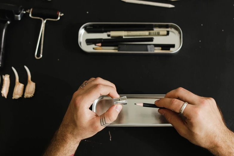 a close up of a person holding a cell phone, an airbrush painting, pexels, arbeitsrat für kunst, surgical implements, metal lid, medium: black pencil, rectangle