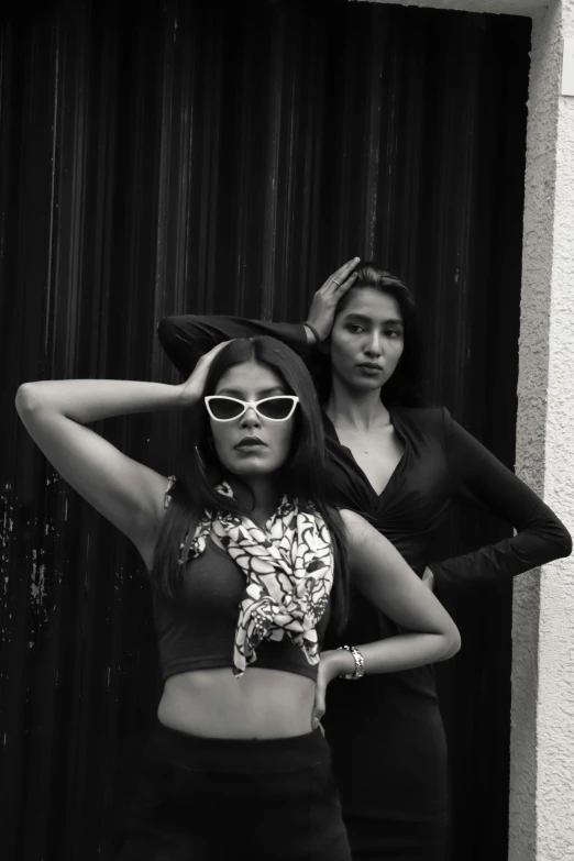 a couple of women standing next to each other, a black and white photo, by reyna rochin, trending on pexels, indian super model, wearing shades, trending on artstion, lo fi