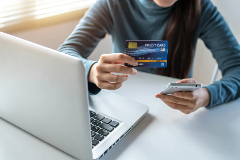 a woman holding a credit card in front of her laptop, a screenshot, trending on pexels, private press, blue and yellow gradient, lachlan bailey, futuristic nft card game, instagram post