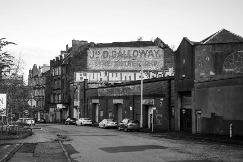 a black and white photo of a city street, by David Allan, graffiti, glasgow, dilapidated neon signs, 2 0 2 2 photo, gallows