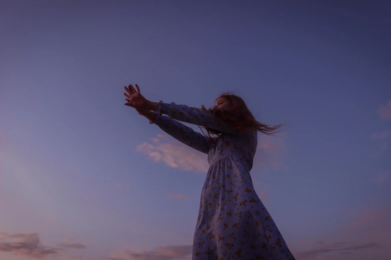 a woman is throwing a frisbee in the air, an album cover, unsplash, evening sky, anya taylor-joy, blue, low angle