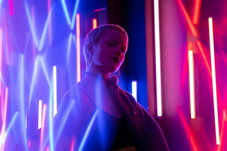 a woman standing in front of neon lights, pexels contest winner, light and space, brienne of tarth, bisexual lighting, behind the scenes photo, joel fletcher