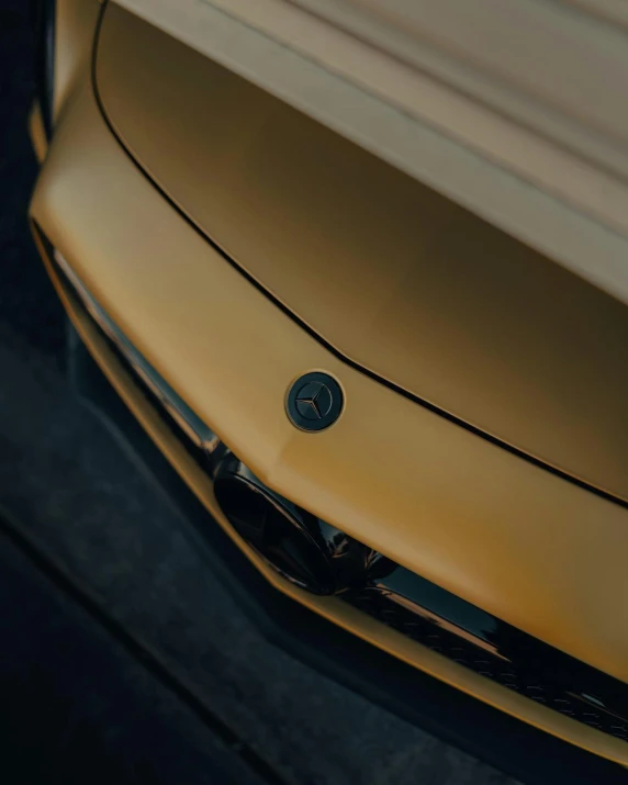 a close up of the hood of a yellow sports car, an album cover, inspired by Harry Haenigsen, unsplash contest winner, bmw and mercedes concept cars, gold medal, round format, alessio albi