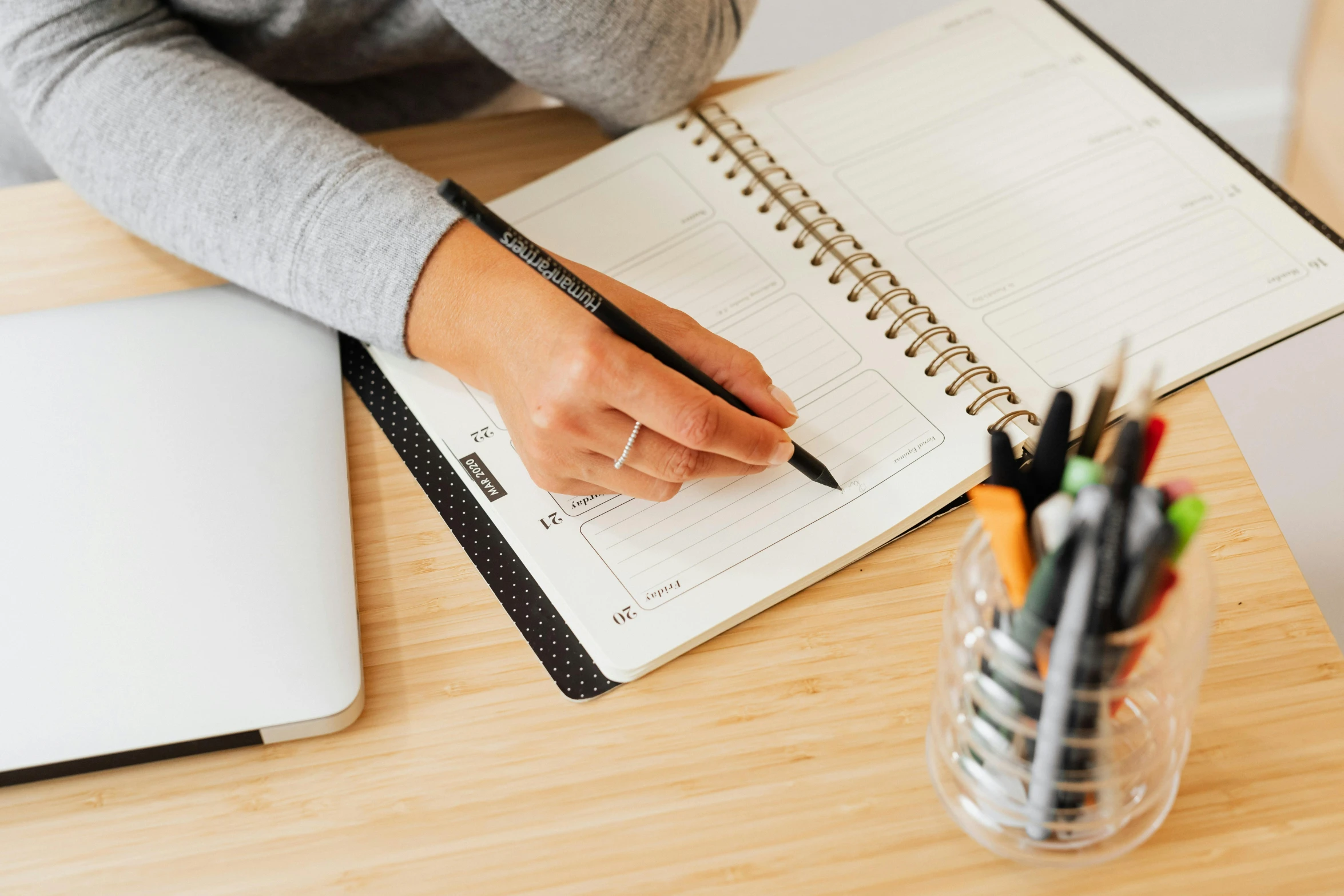 a woman sitting at a desk writing in a notebook, trending on pexels, thick and bold black outlines, educational supplies, weekly, a wooden