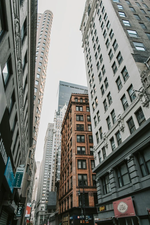 a city street filled with lots of tall buildings, unsplash contest winner, modernism, americana architecture, low quality photo, alleys, low angle photograph