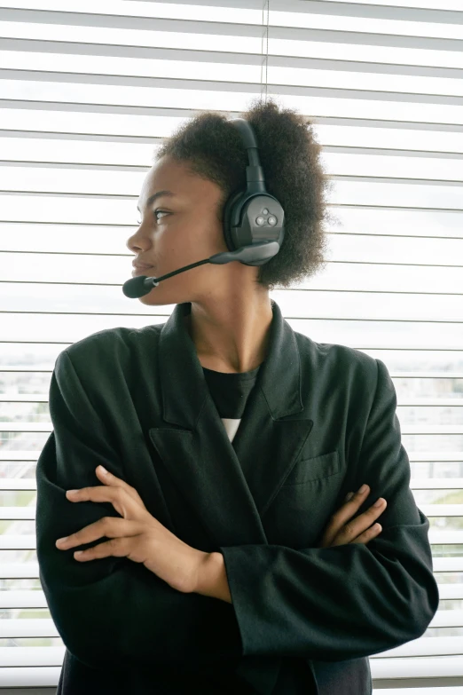 a woman wearing a headset standing in front of a window, sitting down casually, worksafe. dramatic, gaming headset, profile image