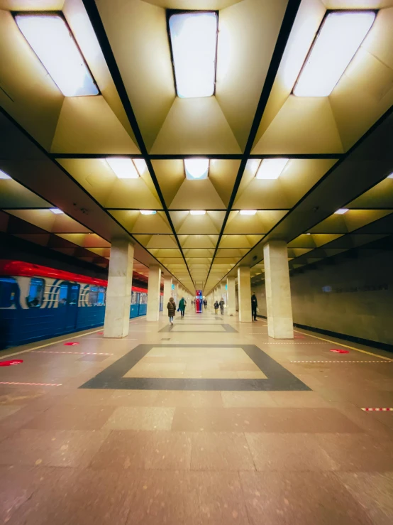 a subway station with people walking on the platform, by Julia Pishtar, fluorescent ceiling lights, soviet architecture, gopro photo, square