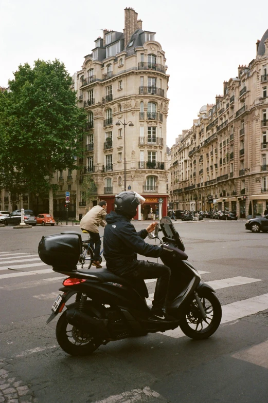 a man riding on the back of a motorcycle down a street, trending on unsplash, paris school, square, at home, high resolution photo, paris hotel style