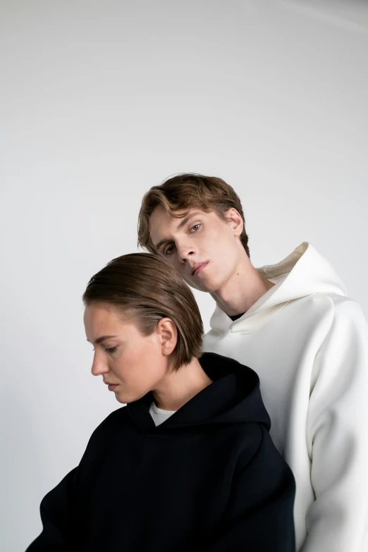 a man and a woman standing next to each other, trending on unsplash, bauhaus, nun fashion model, teen boy, profile image, white backdrop