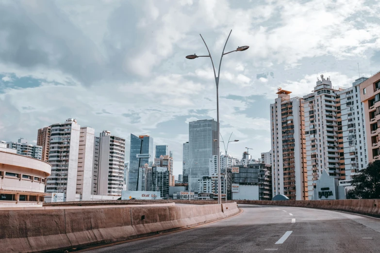 an empty street with tall buildings in the background, by Alejandro Obregón, pexels contest winner, all buildings on bridge, sao paulo in the year 2 0 7 0, puerto rico, skyline showing