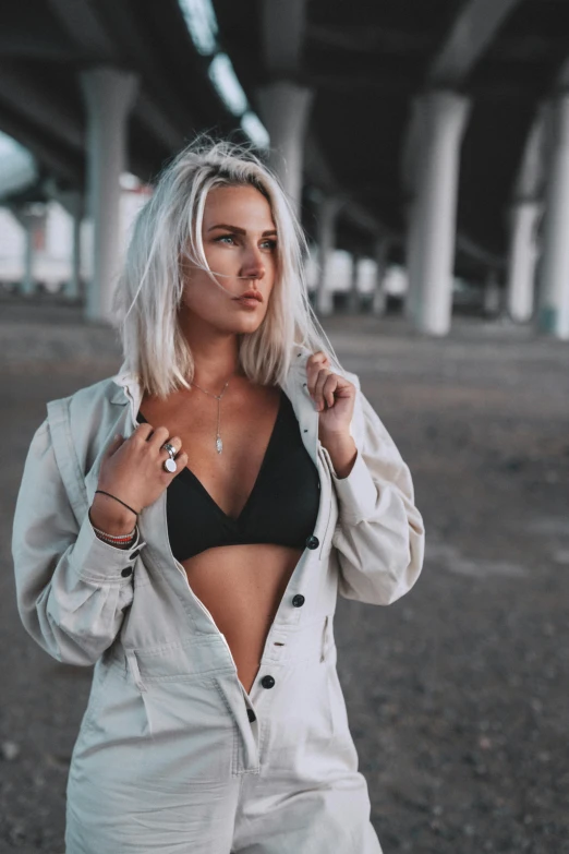 a woman standing in an empty parking lot, inspired by Louisa Matthíasdóttir, trending on pexels, wearing a sexy cropped top, girl silver hair, open jacket, dark backdrop