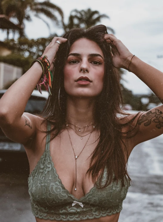 a beautiful young woman standing in the rain, a colorized photo, inspired by Elsa Bleda, trending on pexels, wearing a low cut tanktop, bracelets and necklaces, neck tattoos, hippie chic