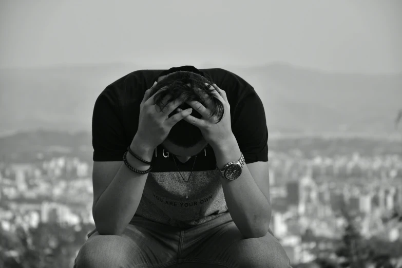 a black and white photo of a man covering his face, a black and white photo, pexels, broken heart, sitting down, sky high level of alcoholism, 15081959 21121991 01012000 4k