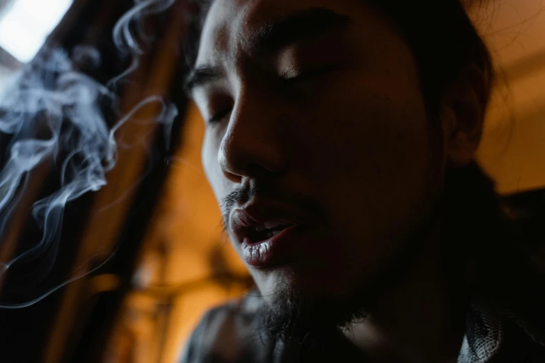 a close up of a person smoking a cigarette, pexels contest winner, asian face, portrait of crazy post malone, smoke under the ceiling, stoic and calm