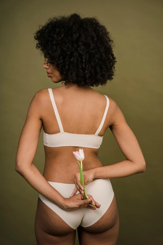 a woman in a white underwear holding a flower, unsplash, back view », clean line, sports bra, various posed