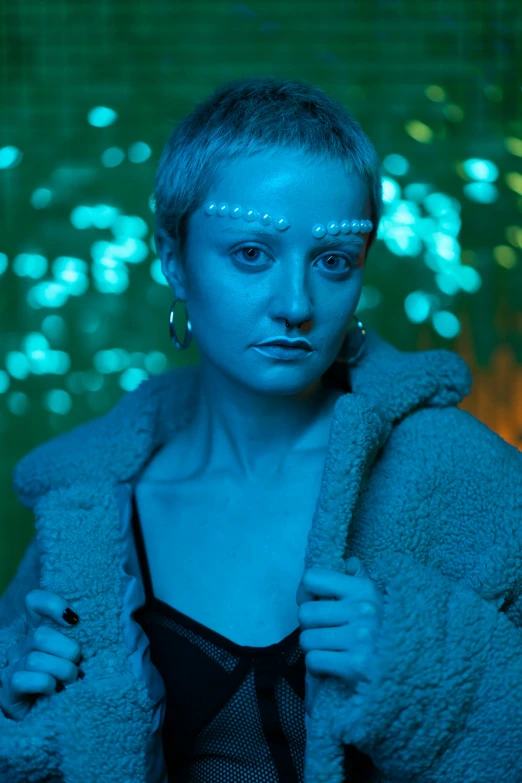 a woman standing in front of a green background, inspired by Elsa Bleda, holography, neon blue glass forehead, scene from bladerunner movie, wearing blue jacket, sophie turner