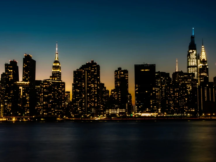 the city skyline is lit up at night, pexels contest winner, ny, fan favorite, shoreline, outdoor photo