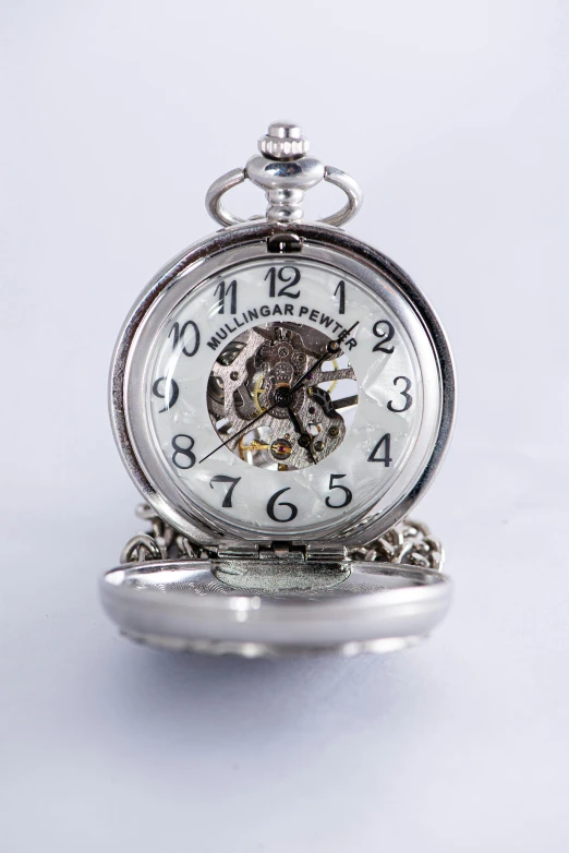 a silver pocket watch sitting on top of a table, inspired by William Gear, studio product shot, 240p, mini, without background