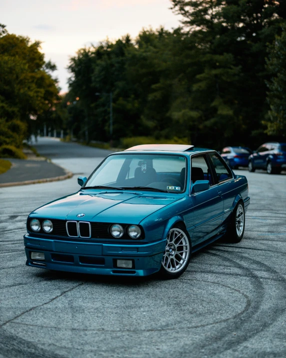 a blue car parked in a parking lot, by Adam Rex, unsplash contest winner, renaissance, bmw e 3 0, 2 0 % pearlescent detailing, 🚿🗝📝, green tint