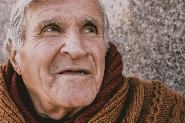 a close up of a person wearing a scarf, by Adam Marczyński, pexels contest winner, photorealism, old male, looking upwards, he is wearing a brown sweater, two old people