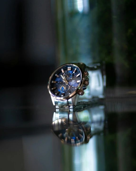 a watch sitting on top of a glass table, by Julia Pishtar, profile image, multiple stories, cobalt coloration, a high angle shot