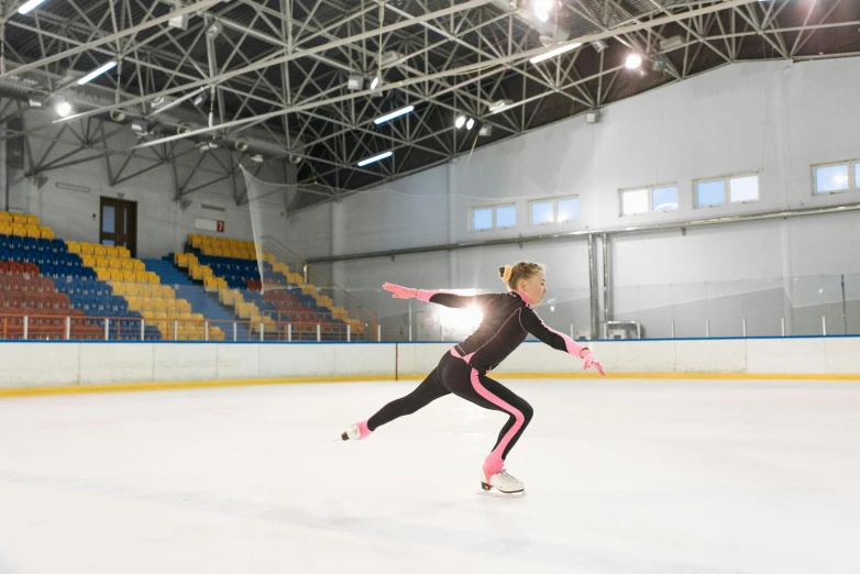 a female figure skating on an ice rink, by Dan Content, shutterstock, arabesque, in spandex suit, sportspalast amphitheatre, indoor picture, thumbnail