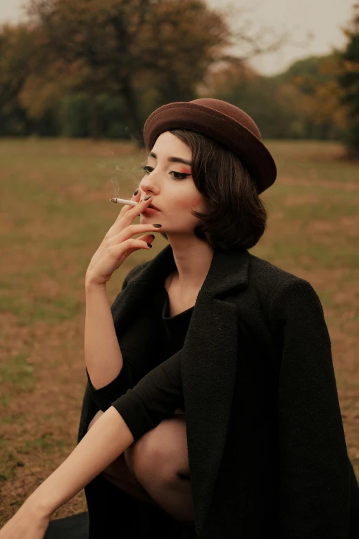 a woman sitting on the ground smoking a cigarette, trending on pexels, aestheticism, an oversized beret, pale-skinned persian girl, profile pic, a man wearing a black jacket