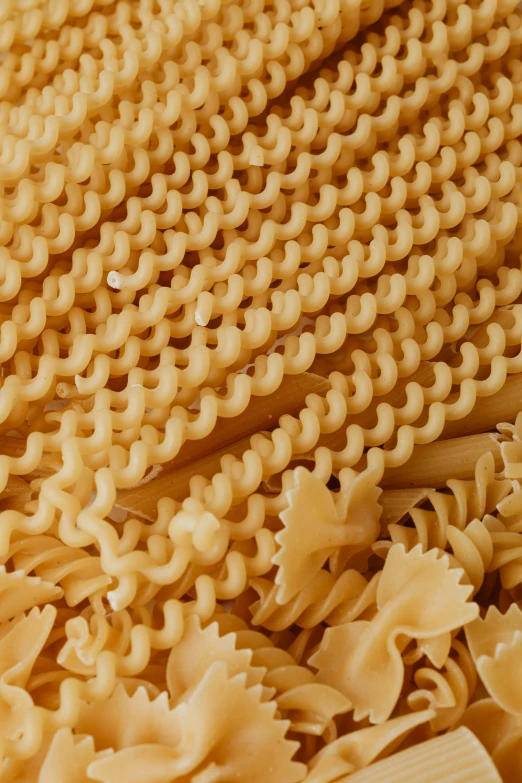 a pile of pasta sitting on top of a wooden table, intricately detailed scales, clear curvy details, neck zoomed in, light tan
